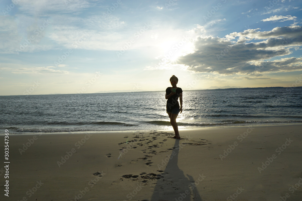 Asain woman walking on the beach waitting for sunset at Thailand