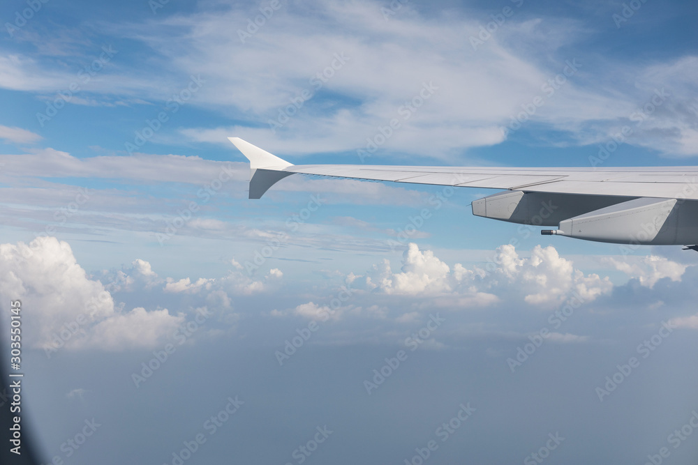 Wing of airliner, in the background beautiful blue sky and clouds. Travel and vacation concept. Wing of airliner, in the background beautiful blue sky and clouds. Travel and vacation concept.