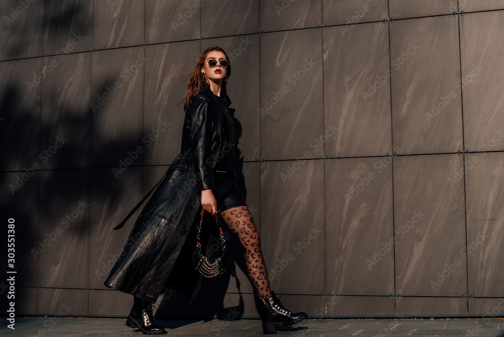 Outdoor full-length fashion portrait of young confident woman