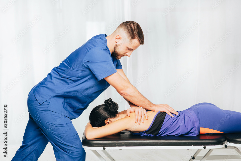 Fotografie Physiotherapist giving back massage to female patient