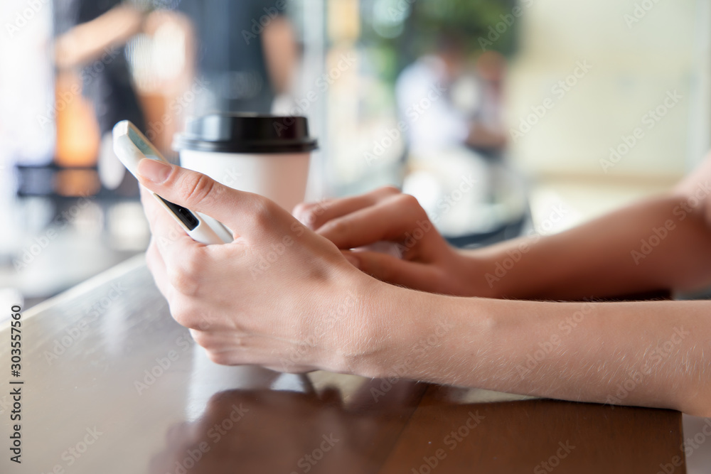 woman hand holding smartphone, working or using internet connection in coffee shop or cafe. Concept of modern working women freelancer, high technology lifestyle woman hand holding smartphone, working or using internet connection in coffee shop or cafe. Concept of modern working women freelancer, high technology lifestyle