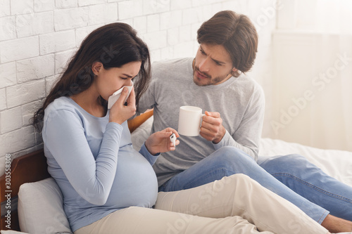 Husband looking after his sick pregnant wife suffering from flu