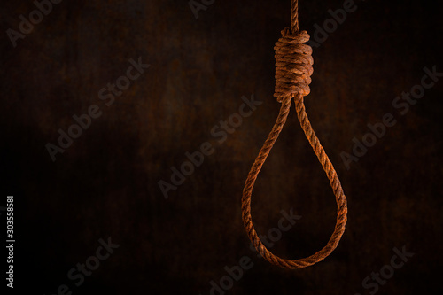 Rusty steel ropes noose for hanging with grunge rust wall background dark black and dim light