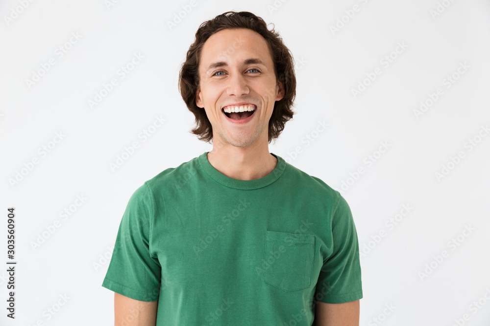 Image of happy young man wearing basic t-shirt smiling at camera Image of happy young man wearing basic t-shirt smiling at camera
