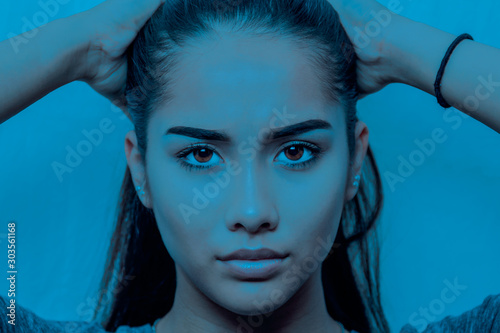 Portrait of young woman face in blue background conceptuat. photo