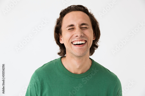 Image of positive brunette man wearing basic t-shirt smiling at camera