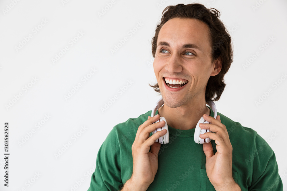 Φωτογραφία Image of joyful brunette man listening to music with headphones