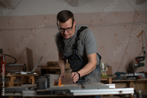 Carpenter-craftsman working on a joiner's machine.