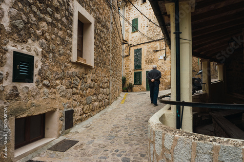 Old man walking besides a laundry in an ancient village