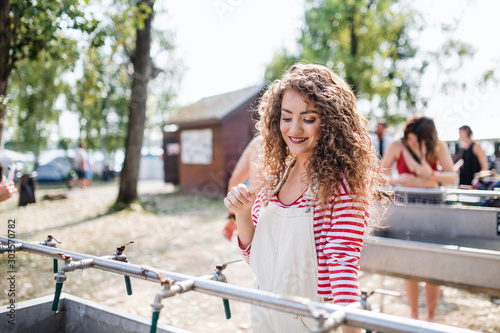 Young woman with tootbrush at summer festival, washing in the morning. photo