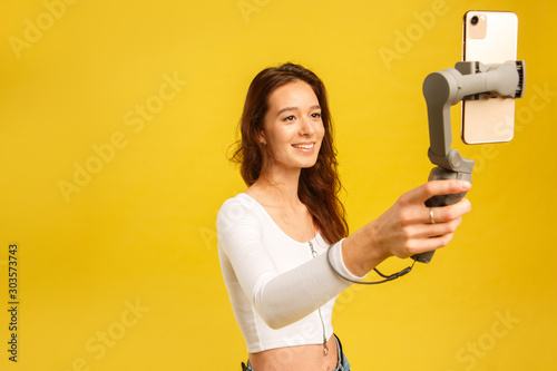 Photography Young blogger girl with three-axis electronic stabilizer gimbal