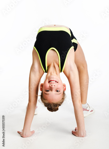 Flexible cute little girl child gymnast doing acrobatic exercise isolated on a white background