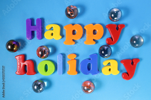 Plastic sign lettering Happy Holiday on blue paper background