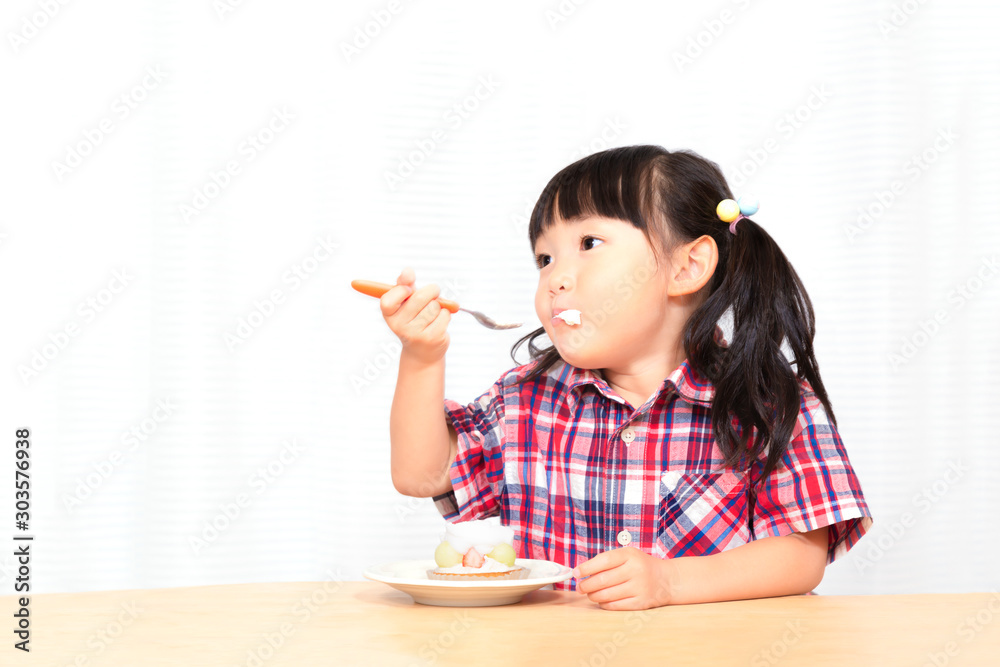 白背景でおやつのケーキを楽しそうに食べる幼い女の子 幸せ 成長 健康イメージ Stock Photo Adobe Stock