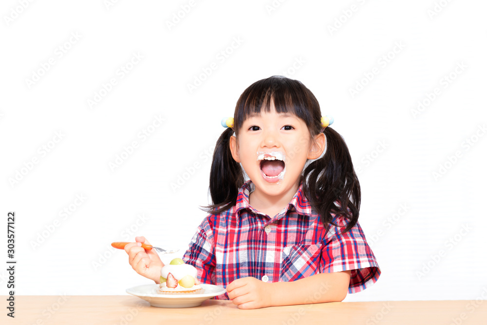 白背景でおやつのケーキを楽しそうに食べる幼い女の子。幸せ、成長、健康イメージ 白背景でおやつのケーキを楽しそうに食べる幼い女の子。幸せ、成長、健康イメージ