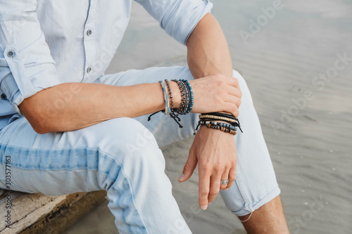 Tableau sur toile Hands of man with bracelets on both hands