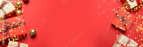 Christmas or New Year banner frame with paper gift boxes decorated with shiny gold ribbons on a red background. 2024