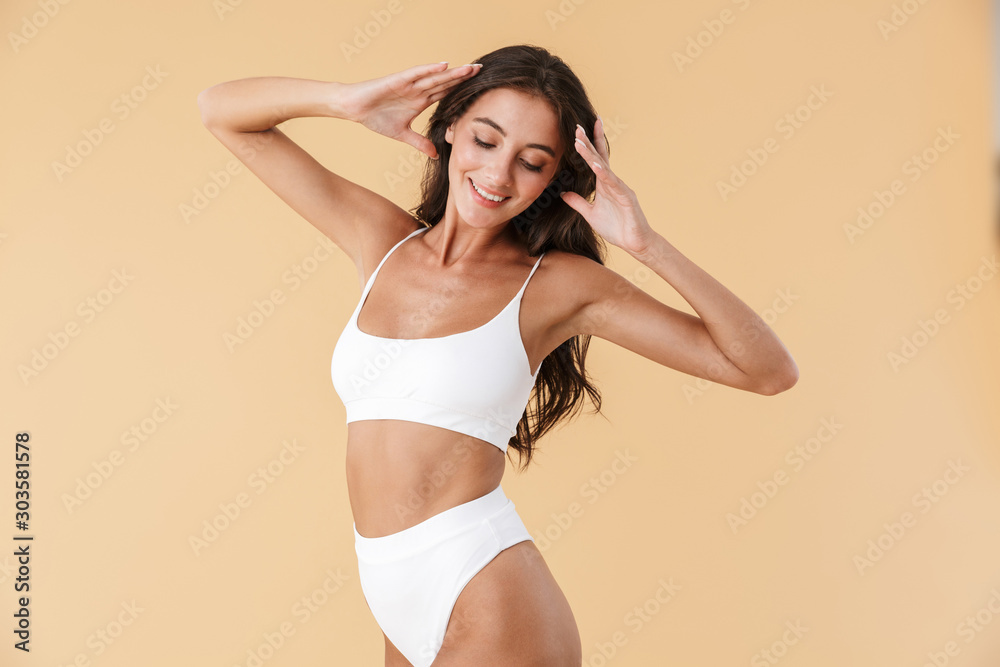 Attractive young slim girl posing in swimwear isolated - obrazy, fototapety, plakaty 