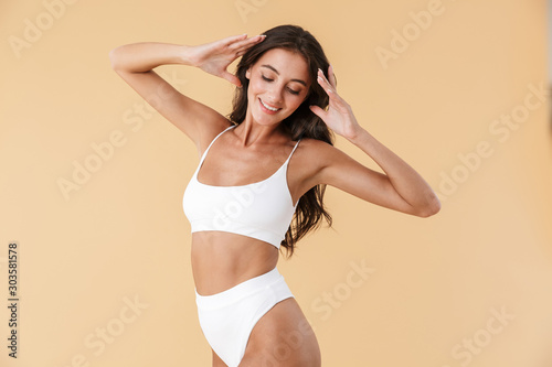 Fototapeta Attractive young slim girl posing in swimwear isolated