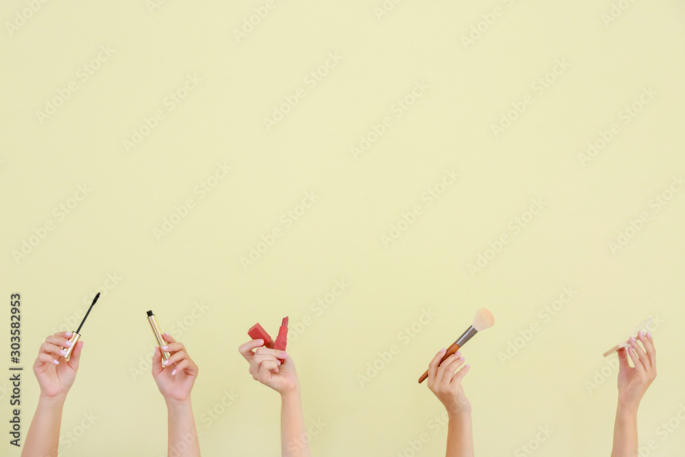 Many hands with decorative cosmetics and brush on color background Many hands with decorative cosmetics and brush on color background