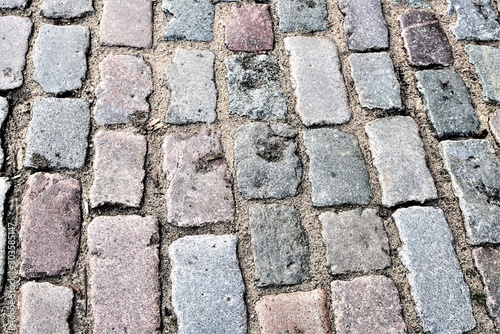 Riga, Latvia, November 2019. A fragment of an old pavement made of stones of different sizes and colors.