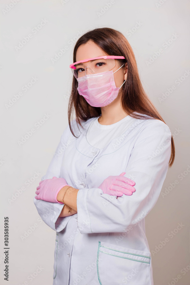Portrait of a girl in a white coat, mask and glasses. Photo on a white background. Portrait of a girl in a white coat, mask and glasses. Photo on a white background.