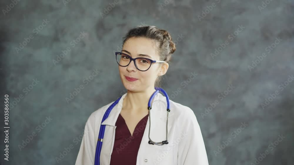 Professional woman doctor with stethoscope and eyeglasses talking to camera. Online video call, distant medical consultation Professional woman doctor with stethoscope and eyeglasses talking to camera. Online video call, distant medical consultation