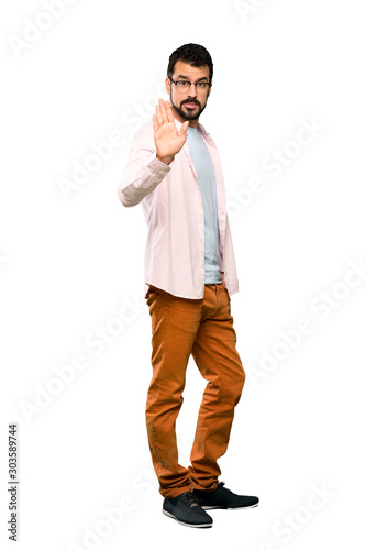 Full-length shot of Handsome man with beard making stop gesture over isolated white background