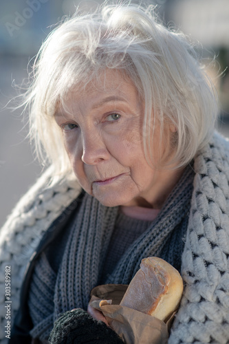 Homeless aged woman feeling miserable and very hungry photo
