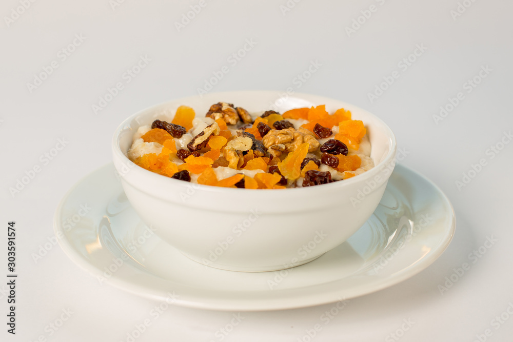 porridge with dried fruits and nuts on a white background porridge with dried fruits and nuts on a white background