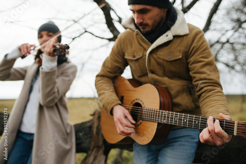 Two musicians practising the art of music in a beautiful leafless autumn forrest