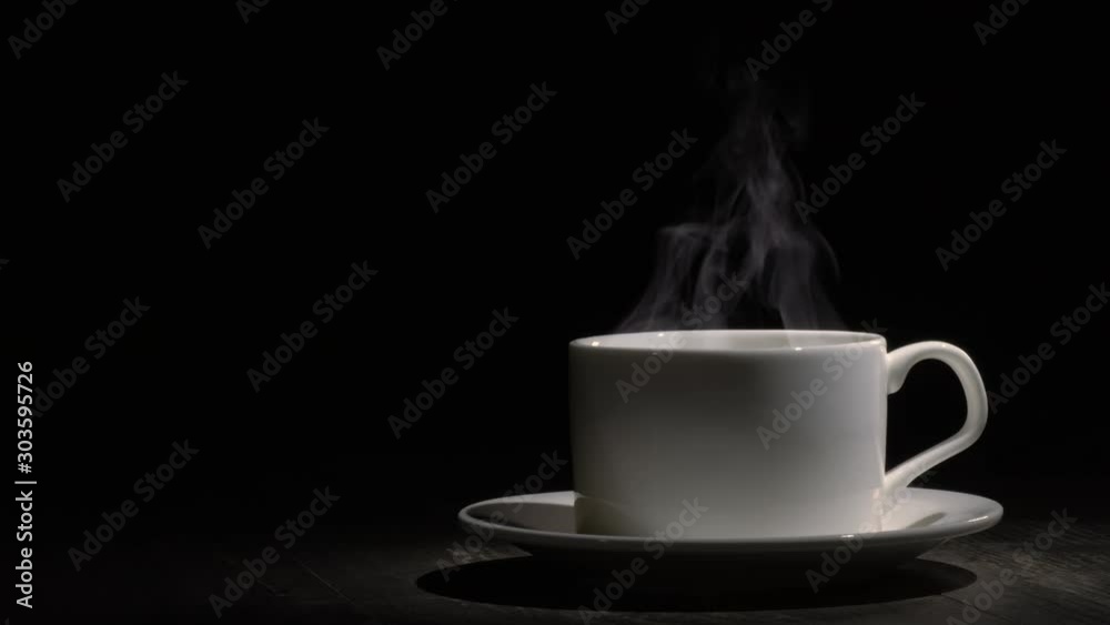 Steam from a cup with boiling water. A trickle of steam rises from a cup of hot coffee. Absolutely black background, you can use to overlay an object. Steam over a cup of hot coffee. Steam from a cup with boiling water. A trickle of steam rises from a cup of hot coffee. Absolutely black background, you can use to overlay an object. Steam over a cup of hot coffee.