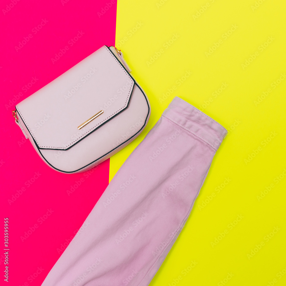 Φωτογραφία Fashionable laid out set: handbag and sleeve of pink denim jacket on fuchsia and bright yellow colored background