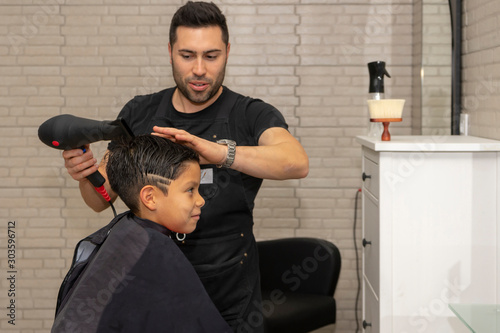 Barber cutting a boy's hair at the barber shop