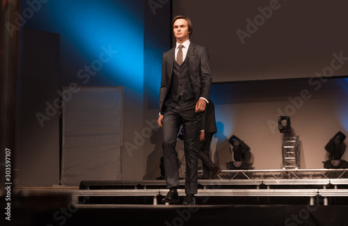 Obraz na płótnie handsome male model posing on the podium w salonie
