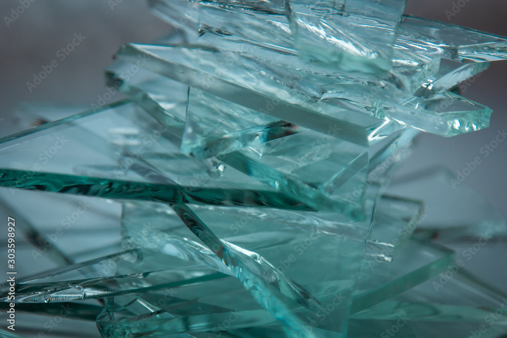 Obraz premium Broken glass background for your images isolated on white. Many large glass fragments scattering from a hammer as a concept of violence.