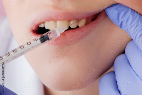 Closeup portrait terrified girl woman scared of needles, syringes, dentist visit siting in chair, opened mouth doesn't want dental procedure drilling tooth extraction