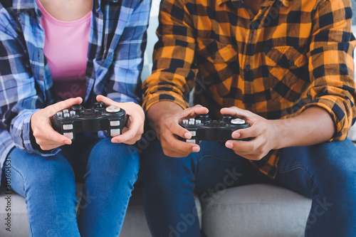 Teenagers playing video games at home, closeup