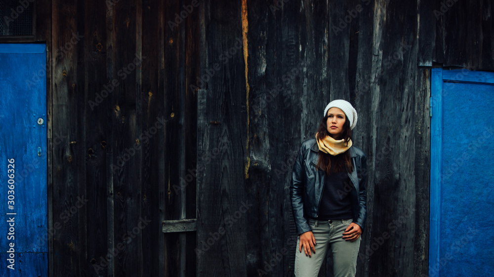 young woman standing near old village house young woman standing near old village house