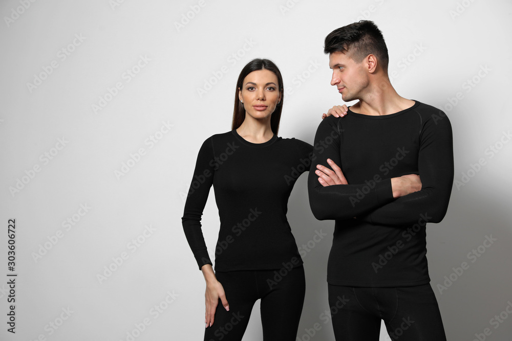 Couple wearing thermal underwear on light grey background. Space for text Couple wearing thermal underwear on light grey background. Space for text
