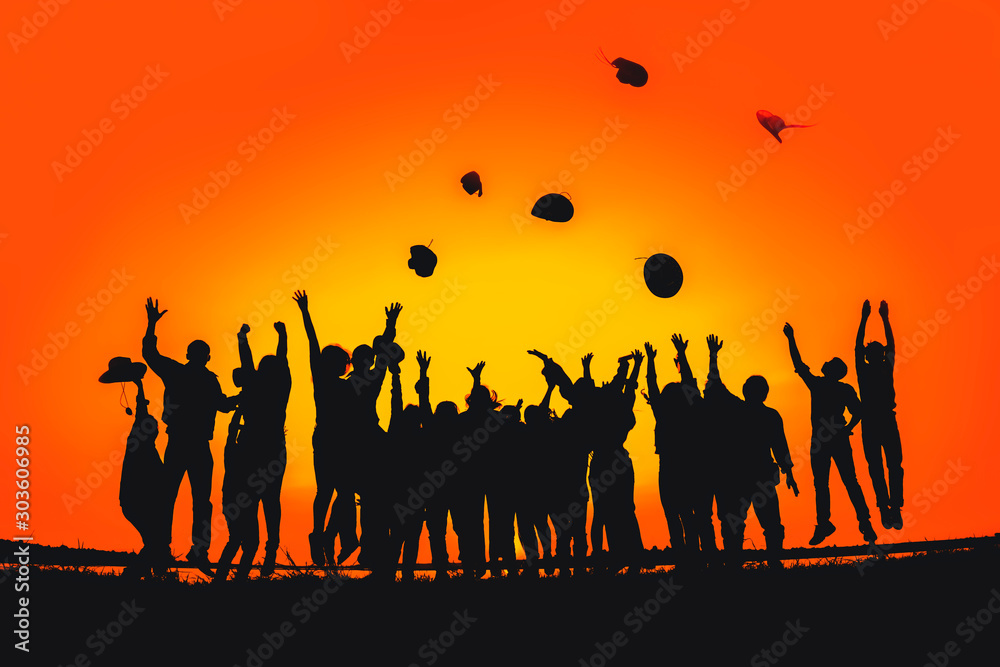 Silhouette of a group of people who jump up and throw a hat showing happiness with success. Silhouette of a group of people who jump up and throw a hat showing happiness with success.