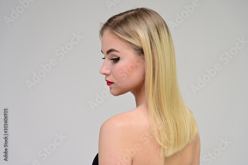 Concept cosmetically, skin rejuvenation. Close-up portrait of a beautiful blonde model on a white background with long hair, excellent makeup, beautiful face and lips.