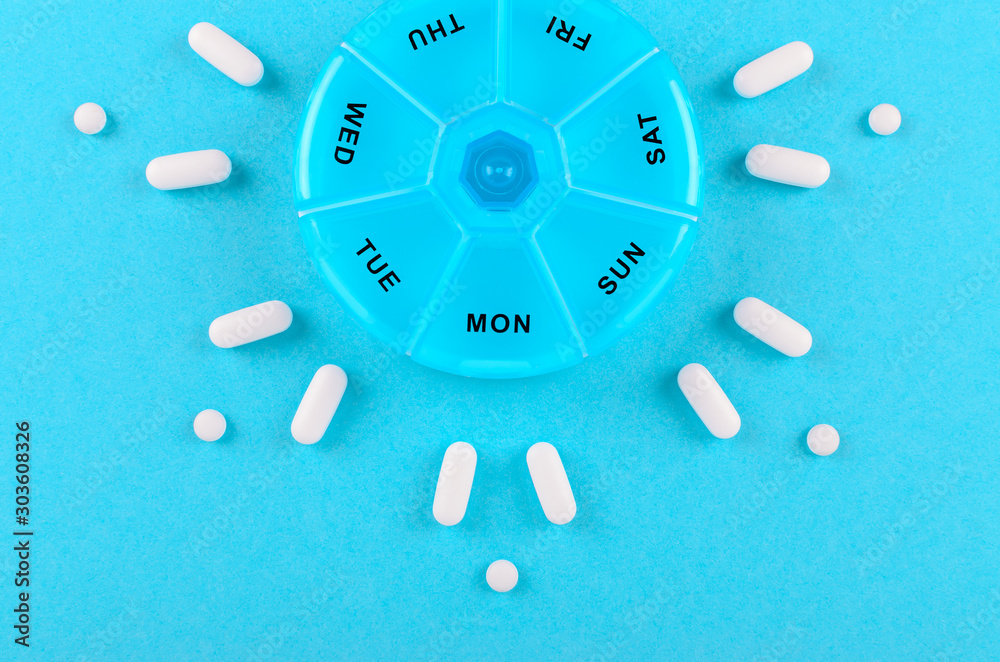 different medicines for one week and a pills box on blue background different medicines for one week and a pills box on blue background