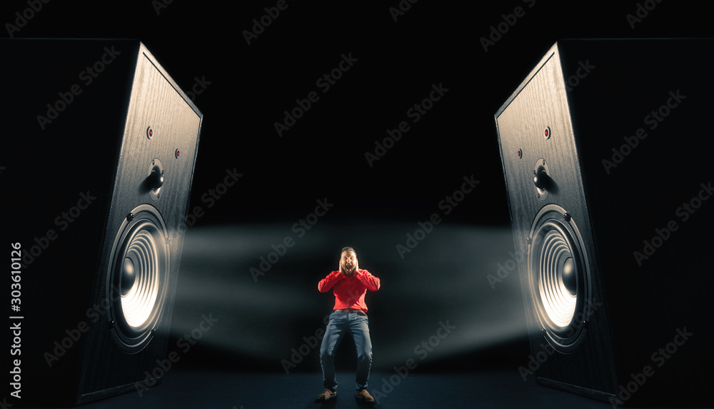 Φωτογραφία The man cover his ears from loud noise wafting out from big sound speakers with funny faces