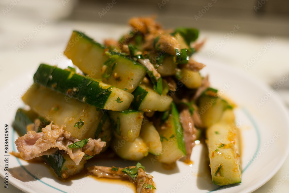 spicy pulled pork and cucumber cold appetiser on a white plate spicy pulled pork and cucumber cold appetiser on a white plate