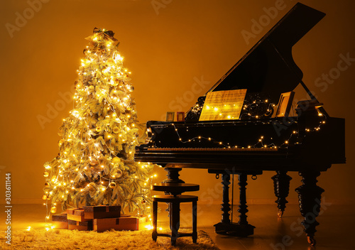 Grand piano in room decorated for Christmas at night