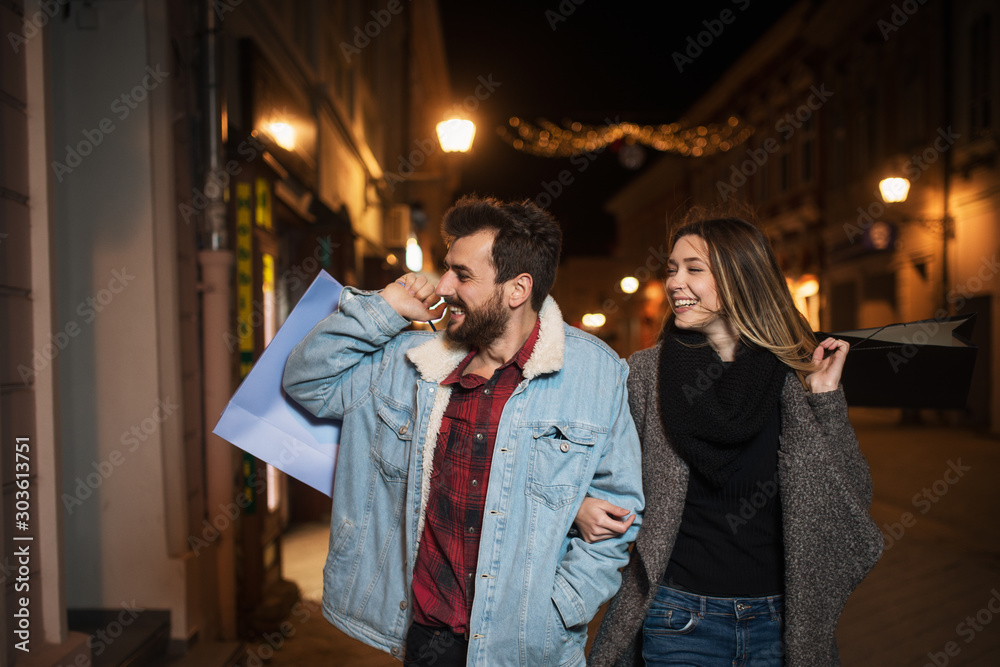 Close up of a young couple shopping in the city at night