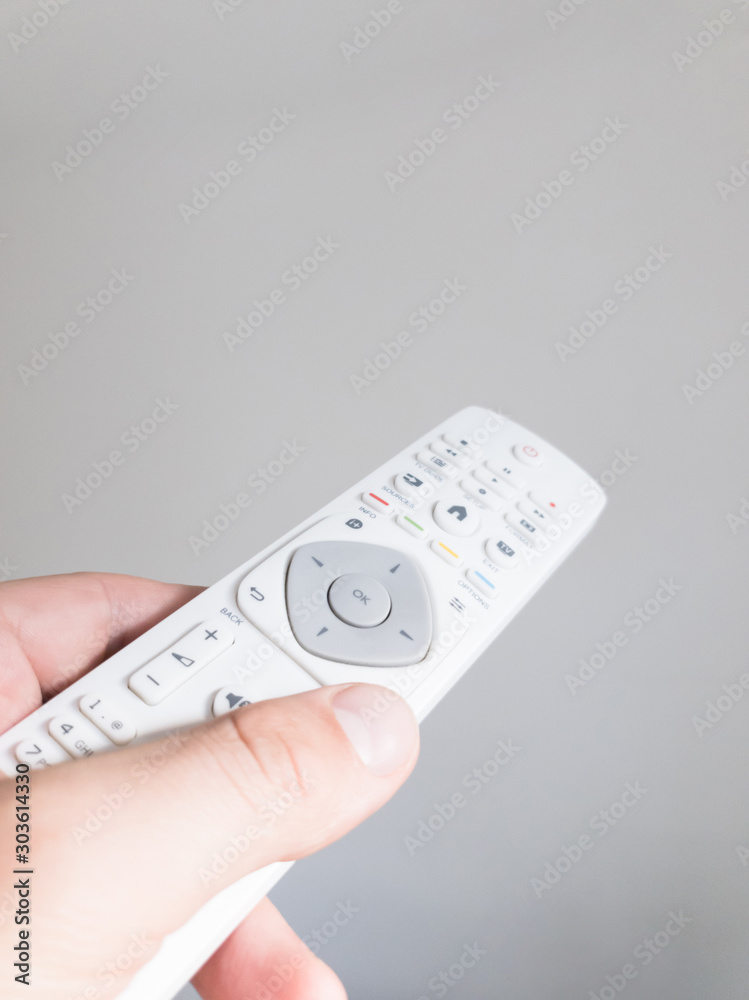 Hand holding TV remote controller on a white background. Hand holding TV remote controller on a white background.