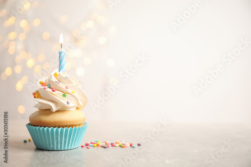 Print op canvas Birthday cupcake with candle on light grey table against blurred lights