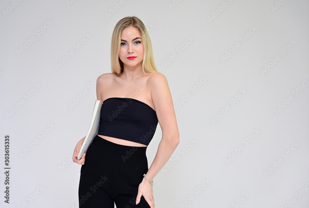 Business training concept with a girl. Portrait of a fashionable beautiful blonde model with long hair, excellent makeup, on a white background with a folder in her hands. Business training concept with a girl. Portrait of a fashionable beautiful blonde model with long hair, excellent makeup, on a white background with a folder in her hands.